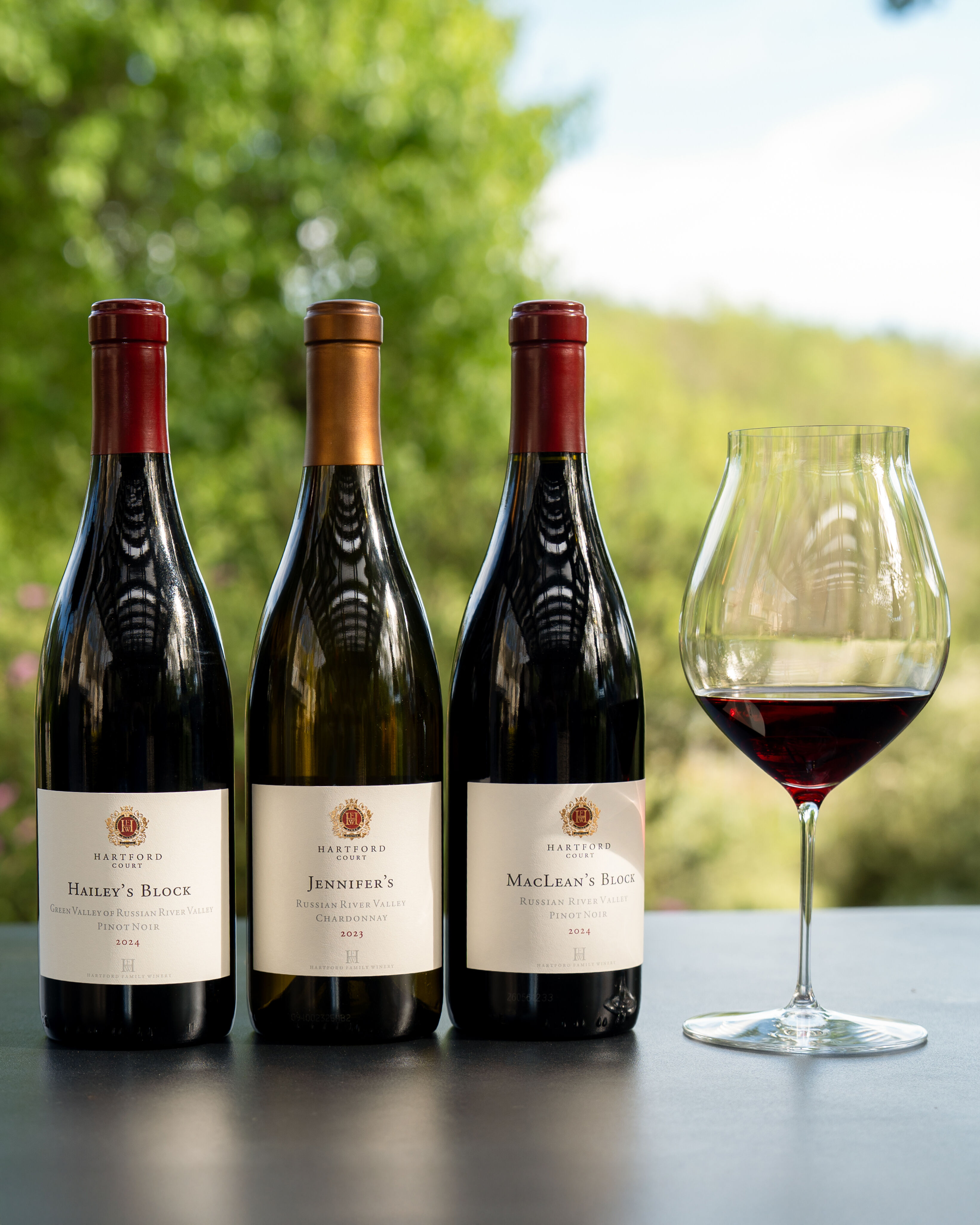 A lineup of Hartford wine bottles with a glass of red wine